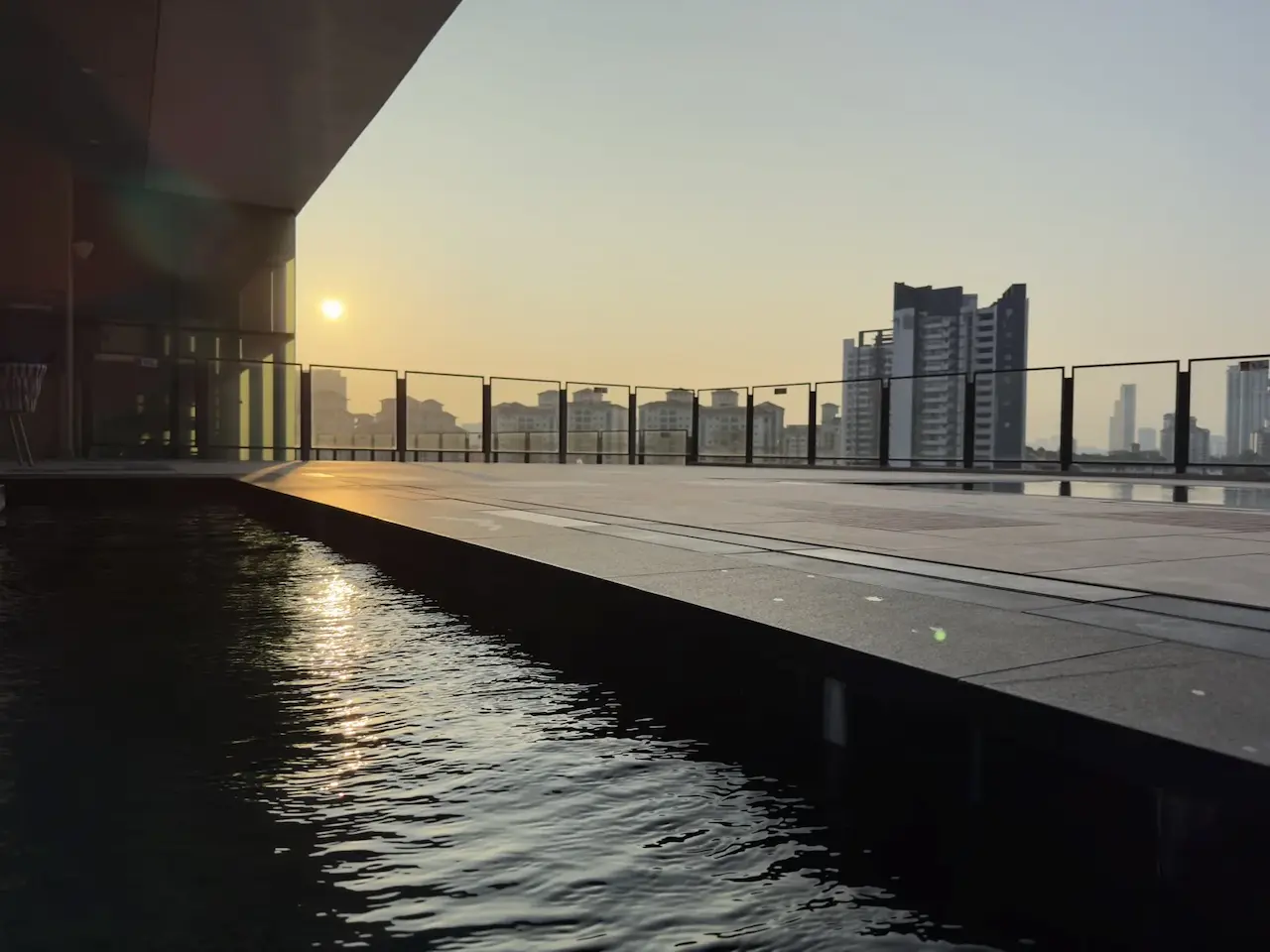 Sunrise over Kuala Lumpur from a rooftop pool, July 29, 2025