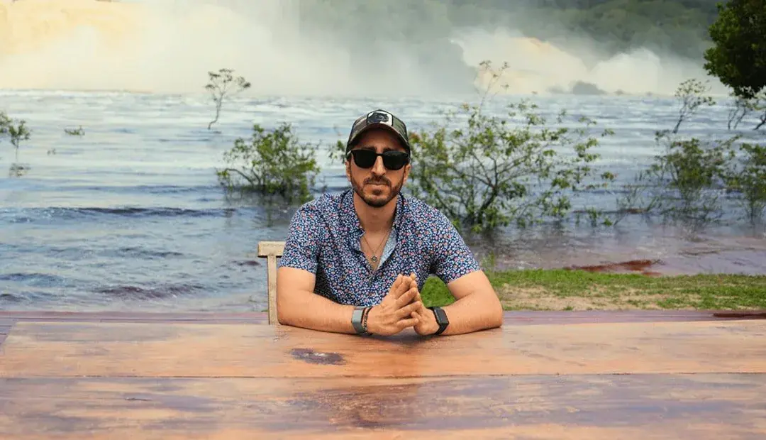 Navid Moazzez working at Waka Wena in Canaima, Venezuela, with the falls behind him