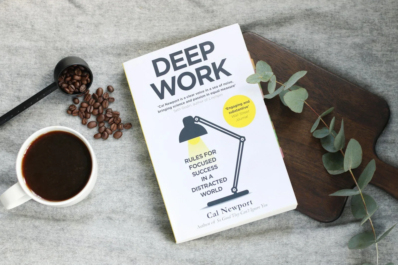 Cal Newport's Deep Work book on a table next to a cup of coffee