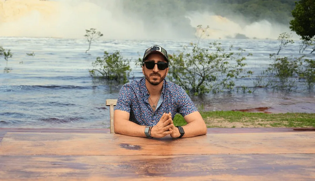 Navid Moazzez working at Waka Wena in Canaima, Venezuela, with the falls behind him