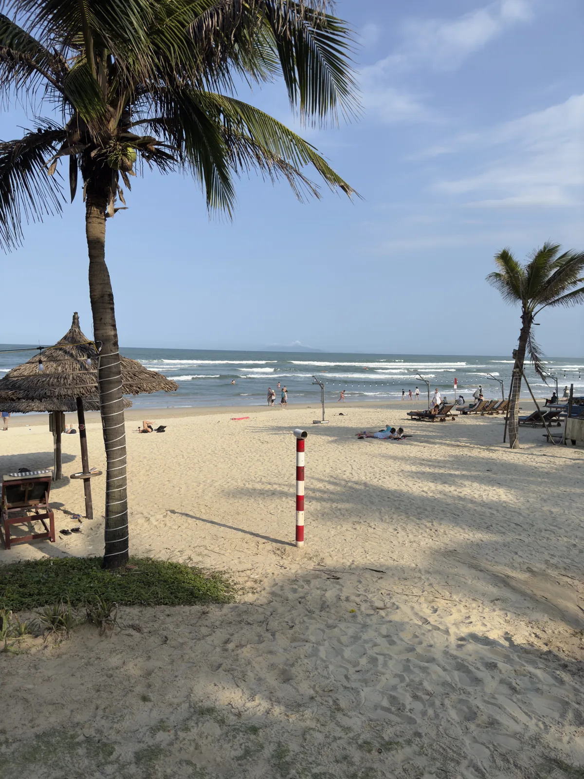 Palm trees and beach huts on My Khe Beach in Da Nang, February 16, 2025